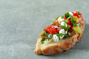 Delicious italian snack bruschetta on gray textured background