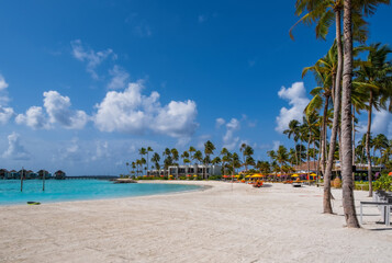 Hotel maldives buildings with palms against the background of emerald water. Group of islands Crossroads Maldives, july 2021. South Male atoll