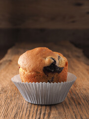 Blueberry muffin on a wooden kitchen table, tasty food, calories