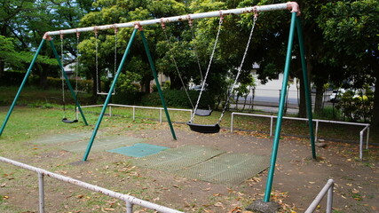 公園のブランコが揺れている