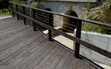 wooden bridge with a stone foundation newly built for cyclists over a stream by the pond. wooden...