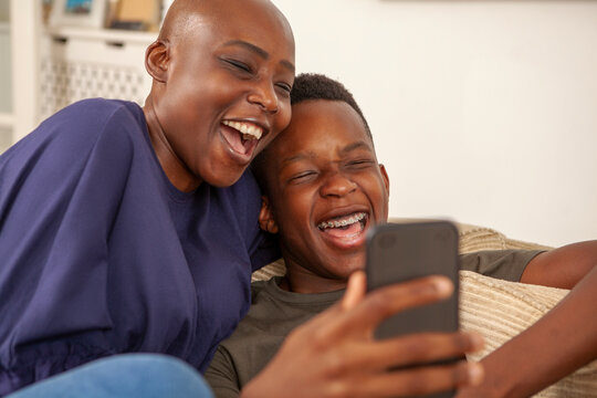Smiling mother and son using phone