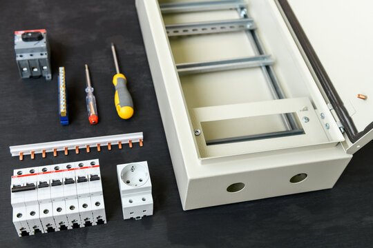 Editorial use only; Assembling the electrical panel: ABB circuit breakers, ABB three-phase switch , zero bus on a black surface, Chelyabinsk, Russia - June 16, 2021.