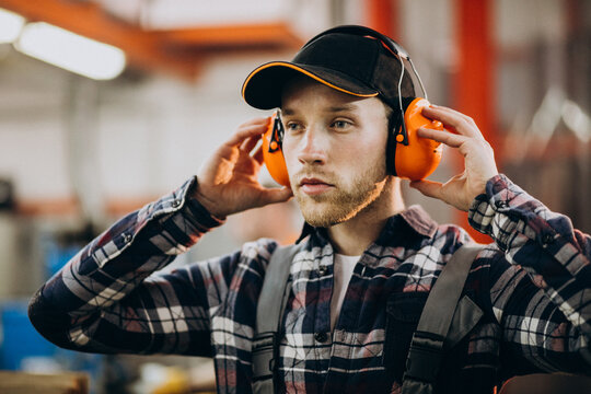Young male handyman with safety earphones