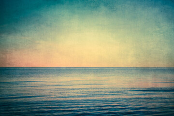 View from beach at sunset with ocean, colorful sky and sea with vintage grunge texture