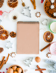 Fototapeta na wymiar Christmas recipe background. Culinary background for a Christmas baking recipe. Notebook with dark sheets for writing a recipe, cookie molds, ingredients, spices, top view, flat lay, copy space