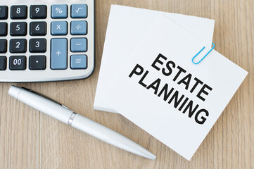 Estate Planning - Business concept, white note paper on the table next to a pen and a calculator