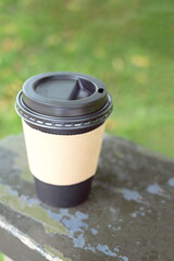 Disposable black coffee cup, take away coffee cup in the park