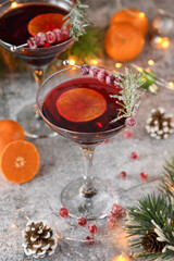 Fototapeta na wymiar Goblet with cranberry Margarita with candied cranberries, rosemary and tangerine. Perfect cocktail for a Christmas party