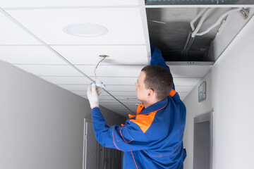 master for installation of hidden wiring and electrical appliances, installs a motion sensor in the suspended ceiling plate