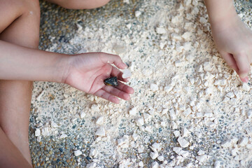 Child's hand holding crystal rock.Mining Science activity fot children.Exploration of minerals for kids.Discovery of rocks.
