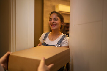 Young woman accepting delivery package at the doorstep.