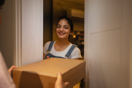 Young woman accepting delivery package at the doorstep.