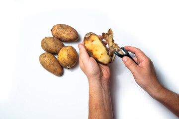 The guy peels potatoes on a white background, In the hands of a rotten potato