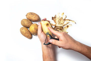 The guy peels potatoes on a white background, In the hands of a rotten potato