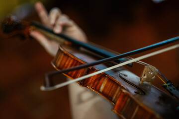Closeup of a female violinist playing violin at the concert, focus on the violin