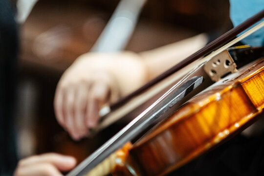 Closeup of a musician playing violin at the concert, focus on the violi