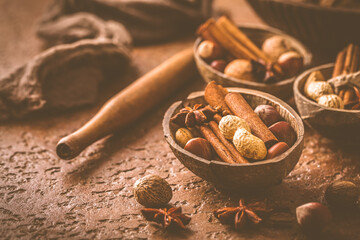 Assortment of different spices and nuts for Christmas baking in warm brown tone