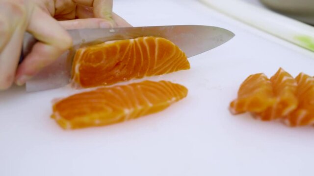 Closeup - home cooking cutting salmon preparing for sashimi and for preserved in shoyu.