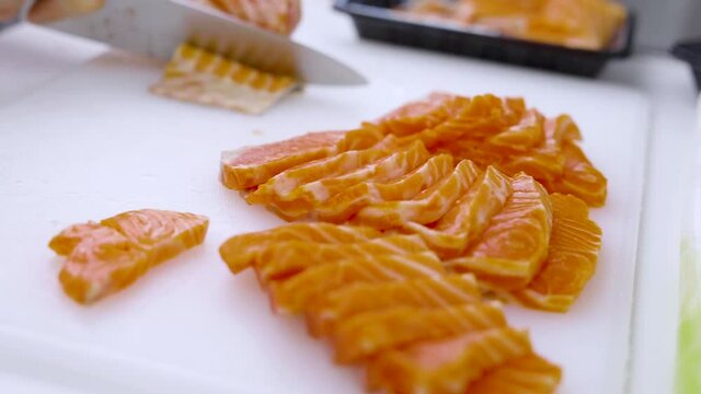 Closeup - home cooking cutting salmon preparing for sashimi and for preserved in shoyu.
