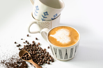hot latte and coffee beans on white background