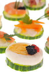 Amuses-bouches avec une rondelle de concombre et une rondelle d'oeuf dur en gros plan sur fond blanc