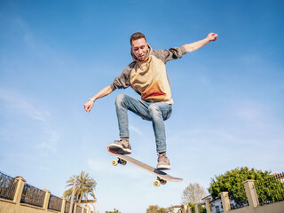 Young man jumping a skateboard in the street. Selective focus