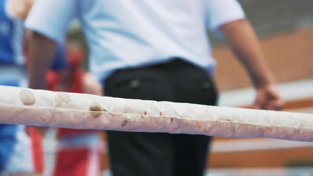 Participants in boxing competitions. Boxing match in ring between men in protective uniform. Fight is held under supervision of referee. Sports competitions in special place. Concept of achievements