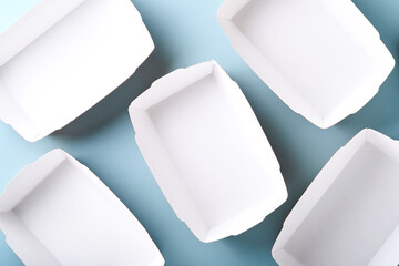 Kraft paper food containers or plate on blue background. Eco craft paper tableware. Recycling and food delivery concept. Mock up. Top view, flat lay.