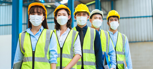 The factory employee consists of engineers, foreman, technicians, and related department staff. Wear a mask, hard hat, and vest. meeting before starting work inside the warehouse. Teamwork concept.