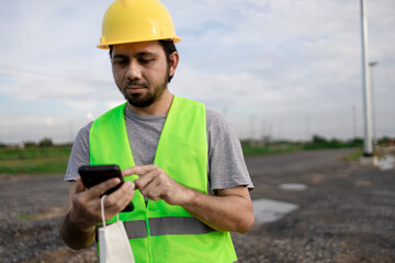 Portrait Asian construction worker using smartphone at the construction site