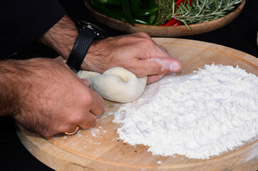 Pizza maker's hands kneading the dough. The cook makes pizza.