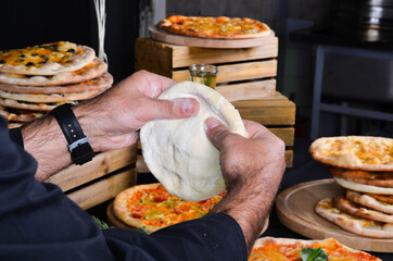 Pizza maker's hands kneading the dough. The cook makes pizza.