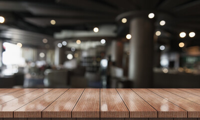 Empty wooden table top with lights bokeh on blur restaurant background.