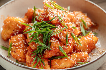 Closeup on fried chicken pieces in sweet and sour sauce