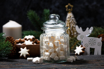 jar with sweet marshmallows and Christmas decorations