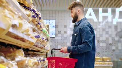 male visitor is buying bread in bakery in supermarket