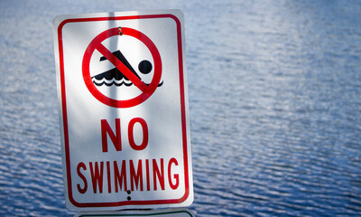 No Swimming sign by water and shade