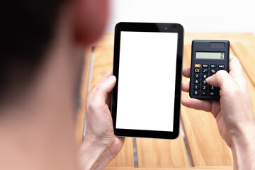 Person doing calculations and looking at a tablet