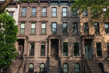 Row of Beautiful Old Brownstone Homes with Staircases along an Empty Sidewalk in Jersey City New...
