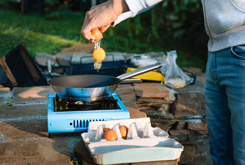 Person cooking omelette on camping stove