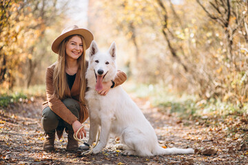 Young woman in park with her white dog
