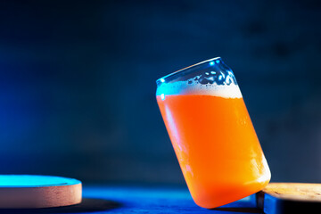 A stylish glass of craft beer on a dark blue background. Indian pale ale copy space