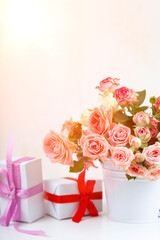 Bouquet of pink roses and boxes with gifts