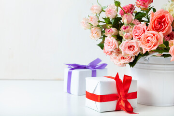 Bouquet of pink roses and boxes with gifts