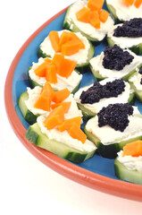 Assortiment d'amuse-bouches à base de concombre dans un plat sur fond blanc