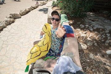 wakacje na plaży z pontonem w cieniu. Chłopak dmuchający materac.