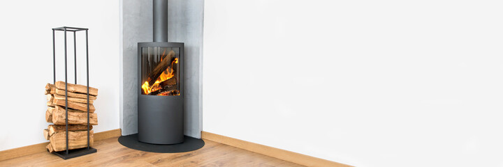Modern wood burning stove. Panoramic contemporary home interior in winter