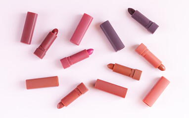 Set of lipstick on pink background flat lay top view