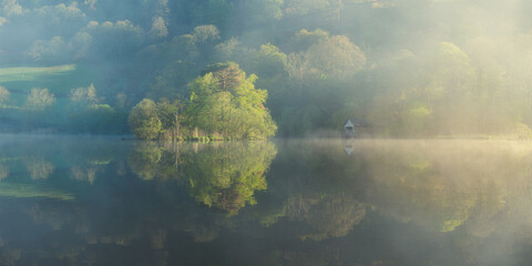 Rydal Water Lake Boathouse Reflections on a Spring Misty Morning, Lake District, UK.